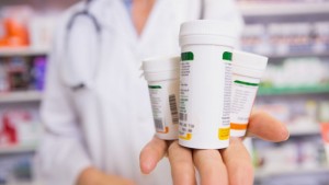 38074016 - pharmacist presenting medications on her hand in the pharmacy